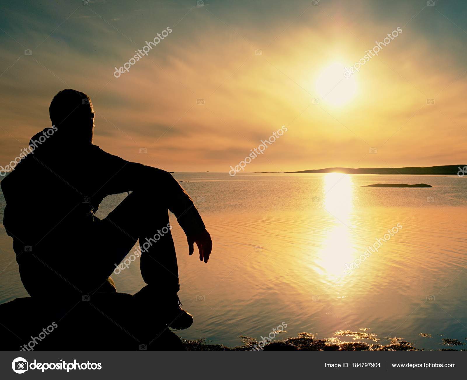 Lonely Man Hiker Sits Alone On Coast And Enjoying Sunset View Over Rocky Cliff To Ocean Stock Photo Image By C Rdonar