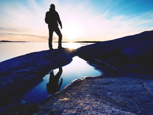 Hermoso atardecer de verano en la playa. Hombre de pie con mochila en el océano contra el atardecer . — Foto de Stock