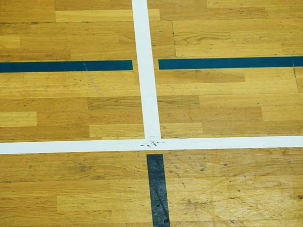 Juega marcas de campo en el suelo en el gimnasio. Suelo de madera desgastado en el pabellón deportivo . — Foto de Stock