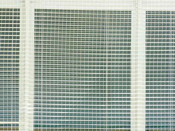 Säkerhetsskydd av windows i idrottsliga hall. Fönstret täckt med vävda skyddsnät. — Stockfoto