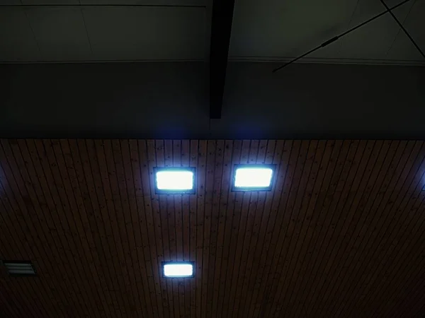 Soffitto luminoso di piastrelle quadrate. soffitto in legno con pannelli di illuminazione . — Foto Stock