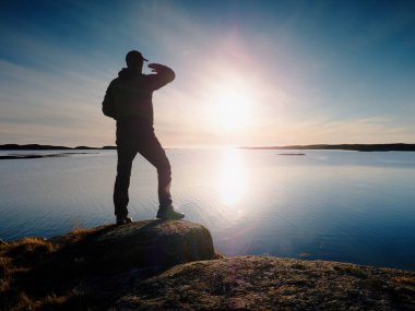 Turist siluet güzel kayalık sahil şeridi sessiz okyanus üzerinde durmak. Uzun boylu uzun yürüyüşe çıkan kimse keyfini çıkarın