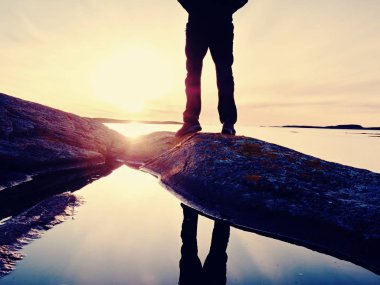 Adam denizde. Gökyüzü ve adam düzgün bir su yansır 