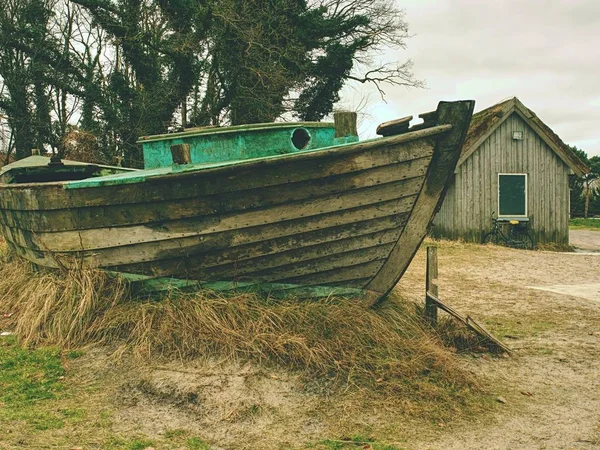 Bateau de pêche naufragé sur vieille herbe sèche. Bateau en bois abandonné avec moteur endommagé — Photo
