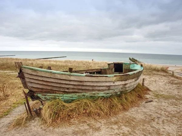 Zničil dřevěnou rybářskou lodí. Rozbité opuštěné lodi v písku zálivu moře. — Stock fotografie