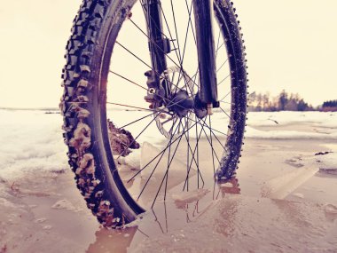 Tekerlek kış mtb gezisi sırasında çamurlu su birikintisi içine düştü. Kar altında gizli su.