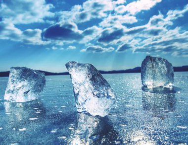 Yansıması ile donmuş gölün yüzeyinde yüzen buz kütlesi buz. Derin çatlaklar