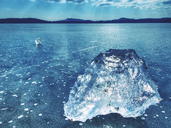 Eisscholle an gefrorener Seeoberfläche mit Spiegelung. Tiefe Risse — Stockfoto