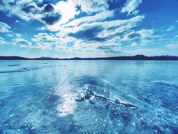 Cacos de gelo num lago congelado. Os raios do sol criam sombras do arco-íris — Fotografia de Stock