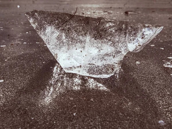 Glänzendes Stück klares Eis auf zugefrorenem See. Risse in vielen Reflexionen der Sonnenstrahlen. — Stockfoto