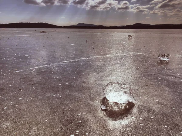 Glänzendes Stück klares Eis auf zugefrorenem See. Risse in vielen Reflexionen der Sonnenstrahlen. — Stockfoto