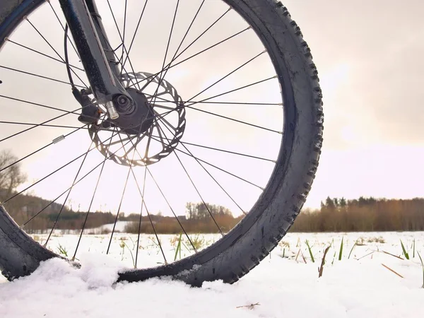 Detalhe da bicicleta dianteira em uma trilha de inverno, caminho coberto de neve. Fundos desportivos — Fotografia de Stock