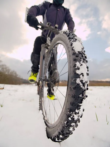 Detalle de la bicicleta delantera en un sendero de invierno, camino cubierto de nieve. Fondos deportivos — Foto de Stock