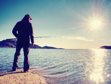 Adam iterek yem kontrol ve çok denize atar. Olta ile balıkçı