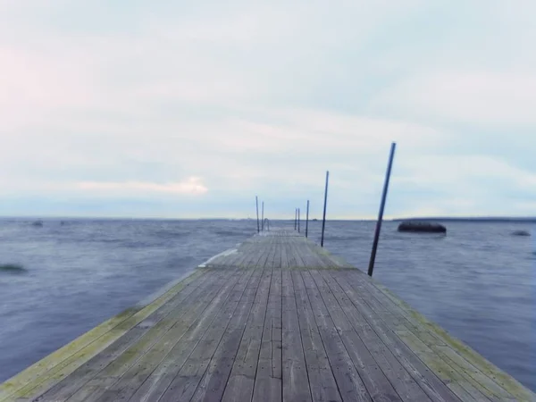 Toupeira de madeira vazia na água do lago azul. Velho cais de pesca para barcos alugados e nadadores . — Fotografia de Stock