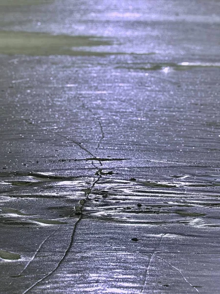 Fragmentos brillantes de hielo agrietado sobresalen en el lago congelado. El efecto de luz se produce — Foto de Stock