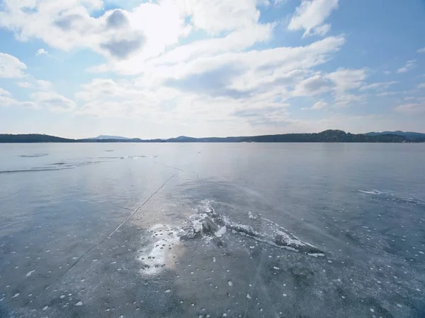 Wintersaison am zugefrorenen Fluss. Leuchtende Eiszapfen auf gefrorenem milchigen Wasserspiegel gebrochen. — Stockfoto