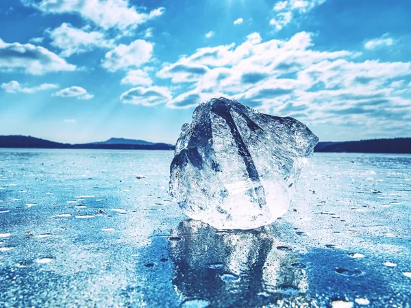 Ice shards on a frozen lake. The rays of the sun creat rainbow shadows