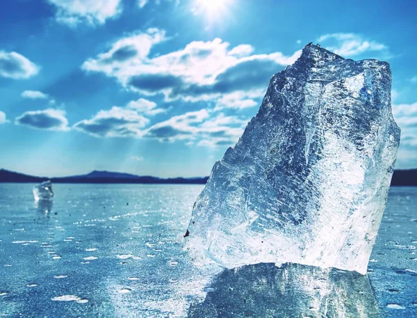 Éclats de glace sur un lac gelé. Les rayons du soleil créent des ombres arc-en-ciel — Photo