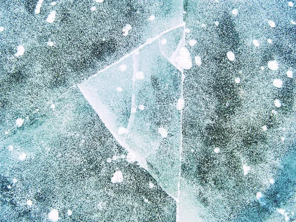 Följ bubblor och spricka i isen på sjön. Speglar solens strålar i is — Stockfoto