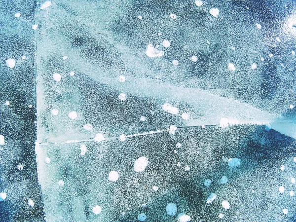 Φυσαλίδες κατεψυγμένα σε λεπτό πάγο. Πολύχρωμο κομμάτι πάγου με ήλιο ακτίνες αντανακλάσεις. Αφηρημένη πάγου — Φωτογραφία Αρχείου