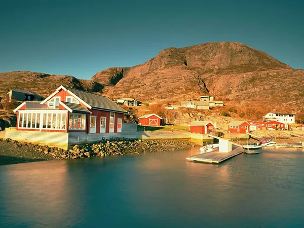 Casas vermelhas da aldeia piscatória. Edifício branco vermelho tradicional no porto pequeno, litoral do mar do norte frio — Fotografia de Stock