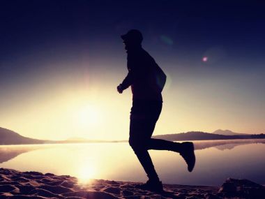 Adam için güzel gün batımı tropikal beyaz kum plaj mavi gökyüzü altında çalışıyor. Plaj sporları