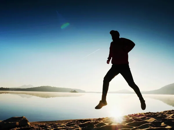 Szczęśliwy człowiek, bieganie i skakanie samodzielnie na plaży — Zdjęcie stockowe