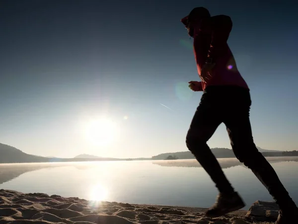 Hombre corriendo a la hermosa puesta de sol en la playa tropical de arena blanca bajo el cielo azul. Deportes de playa — Foto de Stock