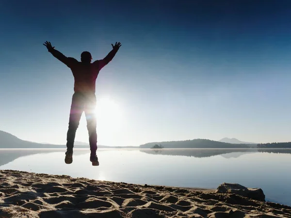 Gelukkig man lopen en springen alleen op het strand — Stockfoto