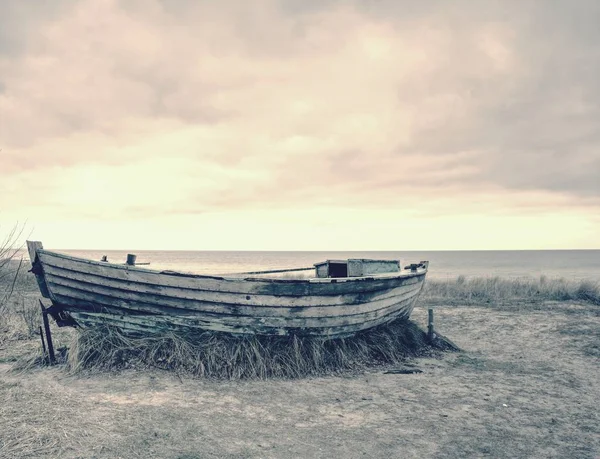 Zničil dřevěnou rybářskou lodí. Rozbité opuštěné lodi v písku zálivu moře. — Stock fotografie