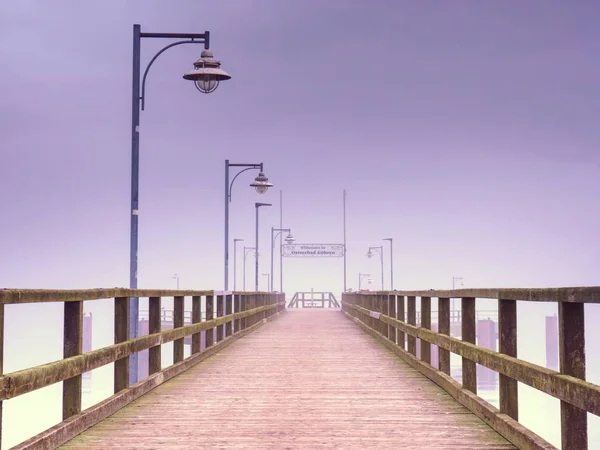 Vecchio ponte sulla spiaggia di legno a Goehren senza nessuno. Tempo nebbioso autunnale — Foto Stock