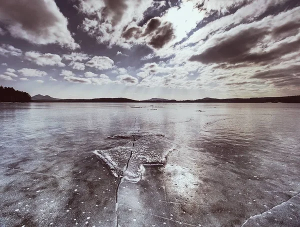 Piatto di ghiaccio alla superficie del lago ghiacciato con riflesso. Fessure profonde — Foto Stock