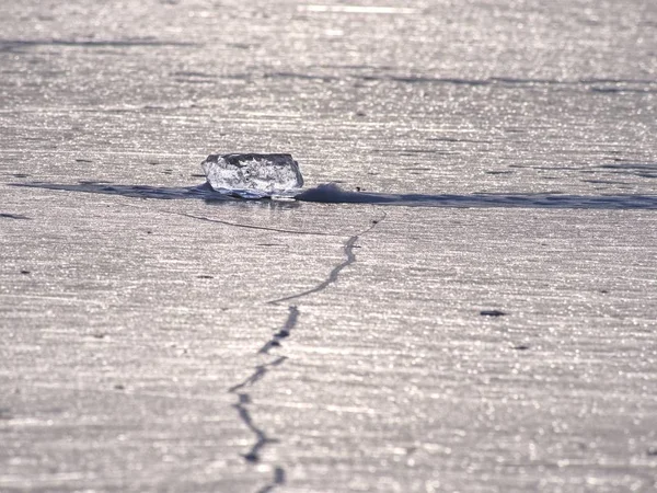 Scherben rissigen Eises ragen aus dem zugefrorenen See. Lichtphänomen tritt auf — Stockfoto
