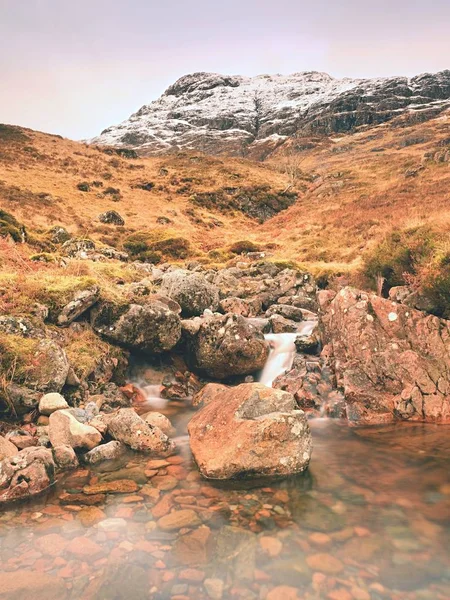 Mountains landscape wild stream in front. White snowy mountain peaks and grey clouds — Stock Photo, Image