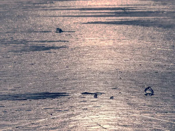 Ocean under transparent ice cover. The sun glare on the flat ice