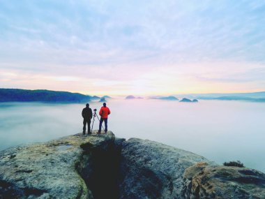 İki sıcak palto fotoğrafçılar tripod ile sonbahar manzara resimleri dağ altında ateş..
