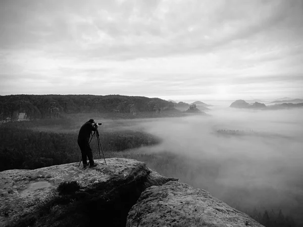 Fotokünstler in Arbeit. Fotograf in den Bergen. Reisender fotografiert majestätische Landschaft, — Stockfoto