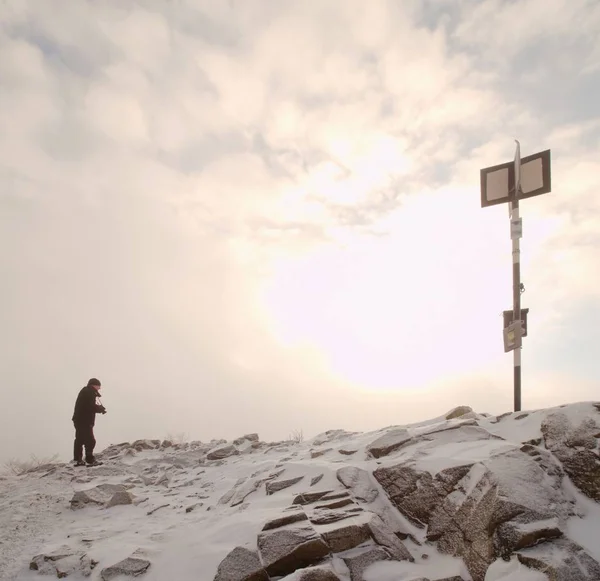 Человек фотографирует замерзающий осенний рассвет, камни с порошковым снегом . — стоковое фото