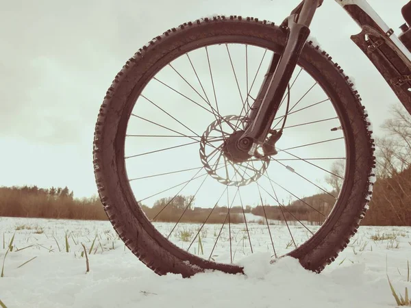 Invierno mtb montar en el país nevado. Vista baja del tobillo a la rueda con neumático de lodo de nieve . — Foto de Stock