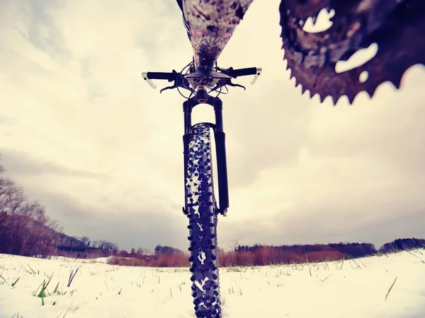 Detalhe da bicicleta dianteira em uma trilha de inverno, caminho coberto de neve. Fundos desportivos — Fotografia de Stock