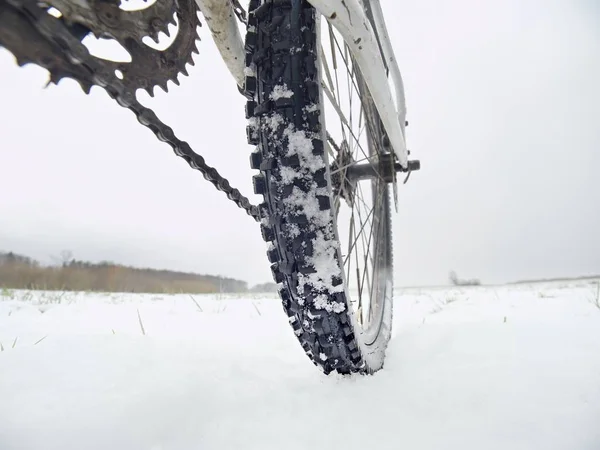 Foto de tobillo bajo de hweel trasero de mtb en snowdrift. Foto tomada durante el viaje en bicicleta de invierno — Foto de Stock