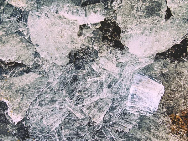 Close-up van stukken van duidelijk natuurlijke ijs op bevroren meer, zeer. Vroege mealting van ijs — Stockfoto