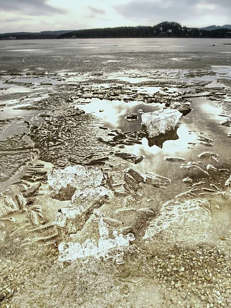 Il ghiaccio si scioglie sulla spiaggia sabbiosa. Dettaglio di lastra di ghiaccio con fessure profonde all'interno — Foto Stock