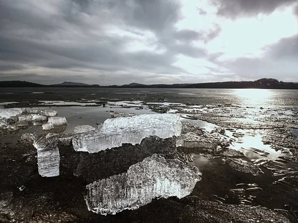 Buz koyda erimesi. Su havuzu üzerinde yüzen buz tabakaları, güneş yansıtan su aynaya. — Stok fotoğraf