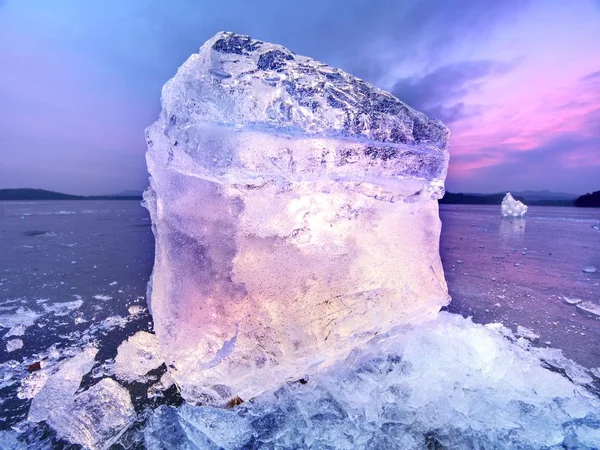 Sciogliere pezzi di blocchi di ghiaccio tritati. Forte retroilluminazione colorata — Foto Stock