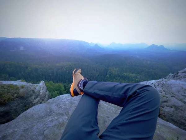 Pernas de um homem sobre pedra. Caminhante descansando em botas para a montanha — Fotografia de Stock