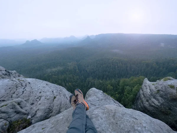 Pernas de um homem sobre pedra. Caminhante descansando em botas para a montanha — Fotografia de Stock