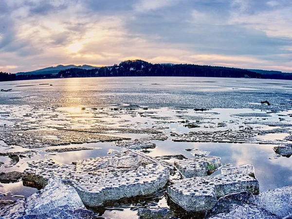 Temné vody jezera přichází a taje bílé ledové kry. Teplá větrný den. — Stock fotografie