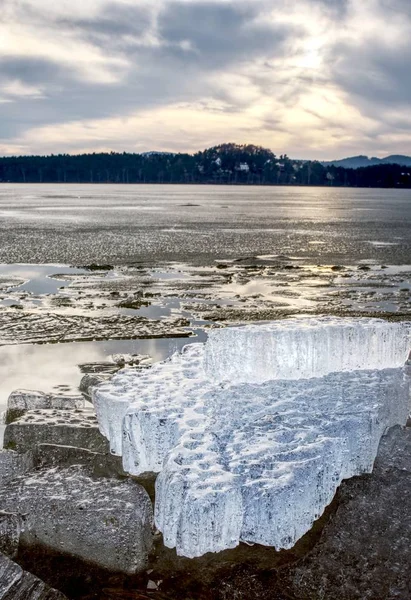녹는 얼음 아래 노출 된 해안입니다. 어두운 물과 얼음 사이 국경에 보기 닫기. — 스톡 사진